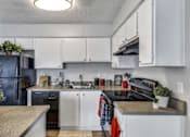 Thumbnail 7 of 17 - A kitchen with white cabinets and a black fridge.at Viva Max, San Antonio, TX 78228  