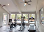 Thumbnail 19 of 19 - A spacious gym with a variety of equipment including treadmills, elliptical machines, and a weight bench.