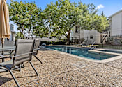 Thumbnail 17 of 45 - A pool surrounded by chairs and trees. at Tradewinds, Windcrest, Texas