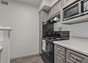 Thumbnail 33 of 43 - A kitchen with a black oven and microwave above it.at Rock 35, Round Rock, 78681