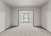 Thumbnail 16 of 43 - A room with a carpeted floor and a doorway leading to a balcony.at Rock 35, Round Rock, Texas