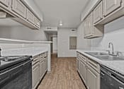 Thumbnail 26 of 43 - A kitchen with wooden floors and white countertops.at Rock 35, Round Rock, TX