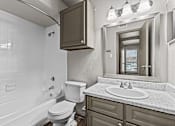Thumbnail 22 of 43 - A white bathroom with a toilet, sink, and mirror.at Rock 35, Round Rock, 78681