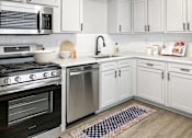 Thumbnail 19 of 79 - a kitchen with white cabinets and stainless steel appliances  at Sunset Heights, Texas