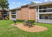 Thumbnail 17 of 29 - A brick building with a picnic table in front of it.