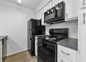 Thumbnail 56 of 58 - a kitchen with white cabinets and black appliances at Vesper, Dallas, Texas