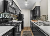 Thumbnail 30 of 58 - a kitchen with black cabinets and white countertops and a black and white checkered tile at Vesper, Dallas, Texas