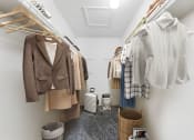 Thumbnail 48 of 58 - a walk in closet with clothes hanging on a rack and a toilet in the corner  at Vesper, Dallas, 75254