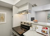 Thumbnail 6 of 63 - a kitchen with a stove and a microwave and a counter with a bowl of food at The Keller, San Antonio, 78230  