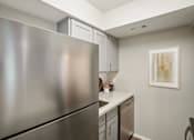 Thumbnail 4 of 63 - a stainless steel refrigerator in a kitchen with light cabinets at The Keller, San Antonio Texas  