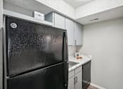 Thumbnail 38 of 63 - a kitchen with a black refrigerator and light color cabinets at The Keller, San Antonio, TX 78230  