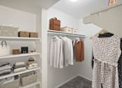 Thumbnail 14 of 63 - a walk-in closet with shelves filled with clothes and bags at The Keller, San Antonio, TX 78230  
