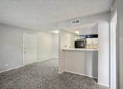 Thumbnail 36 of 63 - the living room and kitchen of an apartment with a carpeted floor at The Keller, San Antonio, TX  