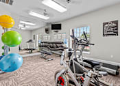 Thumbnail 20 of 42 - a gym with exercise machines and weights and a colorful ball at Southgate Glen, Weatherford, 76086
