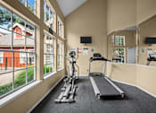 Thumbnail 13 of 32 - A gym with treadmills and exercise bikes.