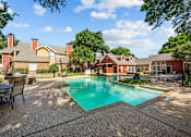 Thumbnail 5 of 32 - A pool surrounded by a patio and trees.