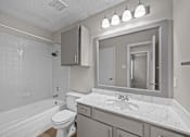 Thumbnail 28 of 32 - A white bathroom with a tub, toilet, and sink.