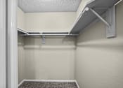 Thumbnail 23 of 32 - A white closet with a shelf and a carpeted floor.