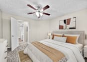 Thumbnail 22 of 32 - A bedroom with a large bed and a ceiling fan.