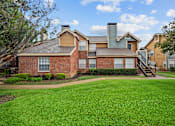 Thumbnail 9 of 32 - A large house with a green lawn in front.