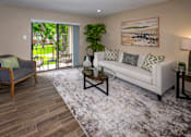 Thumbnail 1 of 10 - A living room with a couch, chair, and a painting on the wall.
