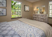 Thumbnail 6 of 10 - A bedroom with a bed, dresser, and window.