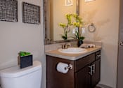 Thumbnail 8 of 10 - A white toilet is next to a sink in a bathroom.