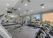 Thumbnail 11 of 28 - A gym with a variety of equipment including treadmills and a rowing machine.