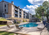 Thumbnail 13 of 54 - a swimming pool with chaise lounge chairs and a building in the background at The Frederick, San Antonio Texas