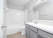 Thumbnail 34 of 34 - A white bathroom with a toilet, sink, and bathtub.