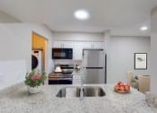 Thumbnail 35 of 54 - a kitchen with granite countertops and stainless steel appliances at The Frederick, San Antonio, TX