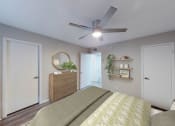 Thumbnail 40 of 54 - a bedroom with a ceiling fan and a bed with a yellow and white comforter at The Frederick, San Antonio Texas
