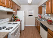 Thumbnail 42 of 45 - a kitchen with white appliances and wooden cabinets at Tradewinds, Texas, 78239