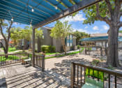 Thumbnail 18 of 58 - a patio with a blue awning and benches and trees in the background  at Vesper, Dallas