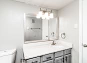 Thumbnail 6 of 27 - A white bathroom with a toilet, sink, and mirror.
