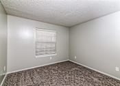 Thumbnail 1 of 27 - A room with a carpeted floor and a window with blinds.