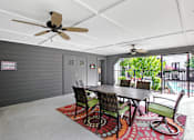 Thumbnail 16 of 27 - A dining room with a table and chairs and a ceiling fan.