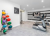Thumbnail 27 of 27 - A gym with a TRUFIT elliptical trainer and a set of multicolored dumbbells.