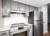 Thumbnail 10 of 27 - A kitchen with a stove, oven, and refrigerator.