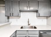 Thumbnail 5 of 27 - A kitchen with a sink and cabinets.