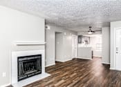 Thumbnail 8 of 27 - A living room with a fireplace and wood floors.