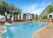 Thumbnail 17 of 27 - A swimming pool in front of a building with a sunny day.
