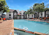 Thumbnail 19 of 27 - A swimming pool with a diving board in front of a building.