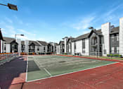 Thumbnail 18 of 27 - A tennis court is surrounded by houses.