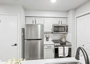 Thumbnail 4 of 47 - a kitchen with white cabinets and stainless steel appliances  at Carmel at Deerfield, San Antonio