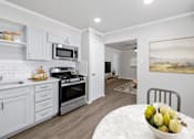 Thumbnail 7 of 79 - a kitchen with white cabinets and a white marble table with a bowl of fruit on it  at Sunset Heights, San Antonio, TX, 78209