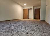 Thumbnail 3 of 15 - an empty living room with carpet and a door to a closet