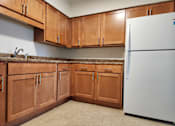 Thumbnail 12 of 15 - a kitchen with wooden cabinets and a white refrigerator