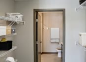 Thumbnail 7 of 54 - Walk-in closet leading to a bathroom with a toilet and a sink
