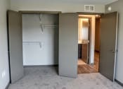 Thumbnail 39 of 54 - A bedroom with a closet and bathroom in the background on the other side of the hallway